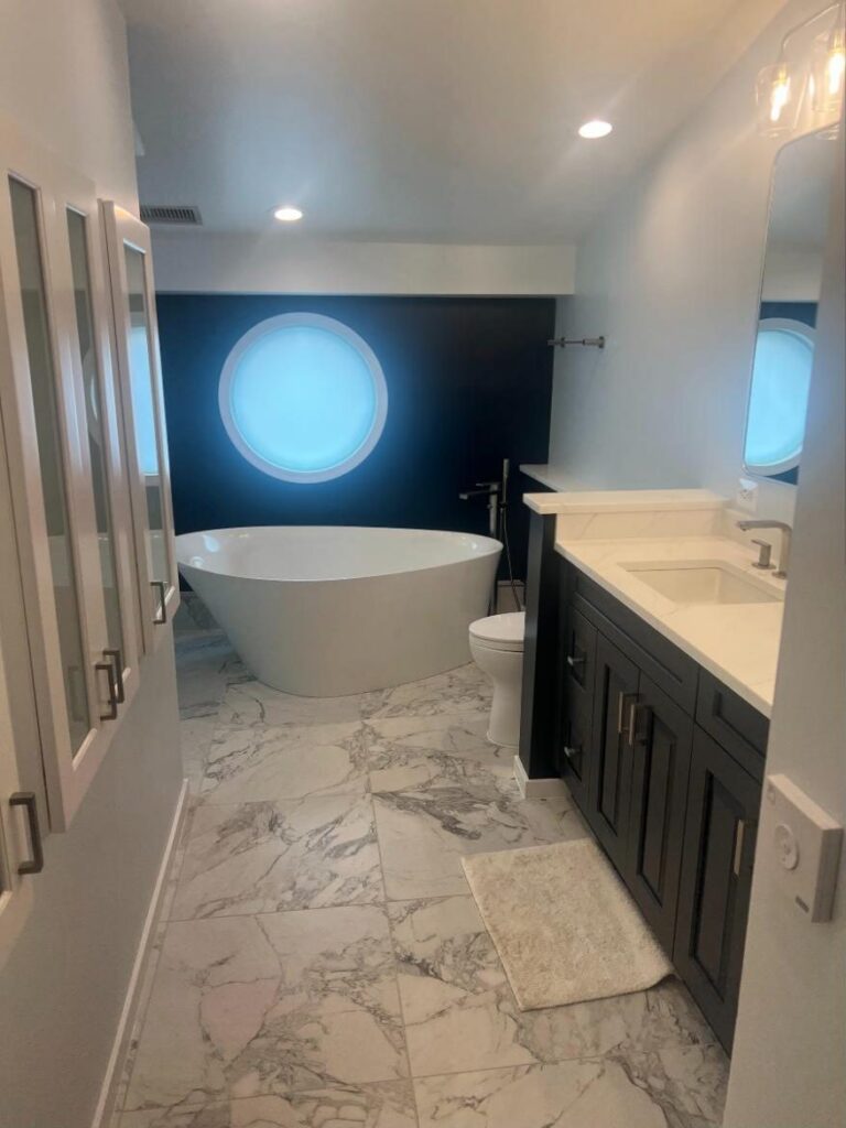 Primary bathroom with freestanding tub and dark double vanity