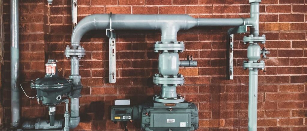 Gas meter and piping on a brick wall