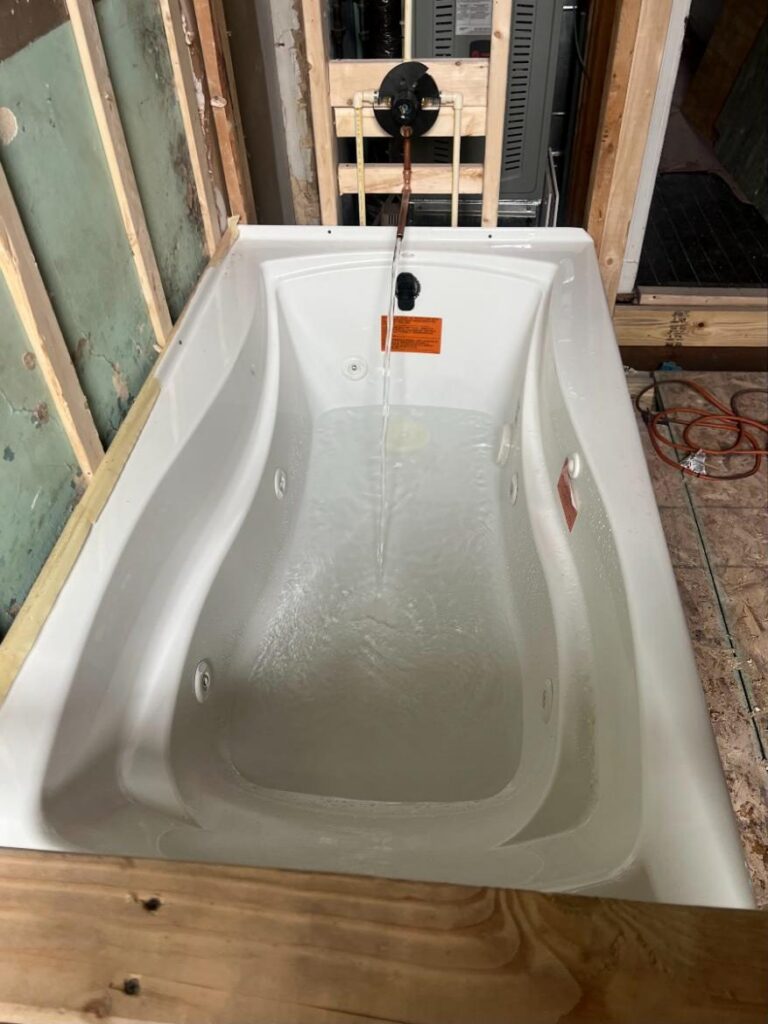 Jetted tub being filled for testing during a gut remodel