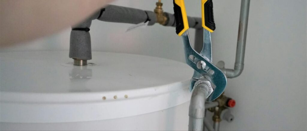 Plumber connecting the top of a water heater
